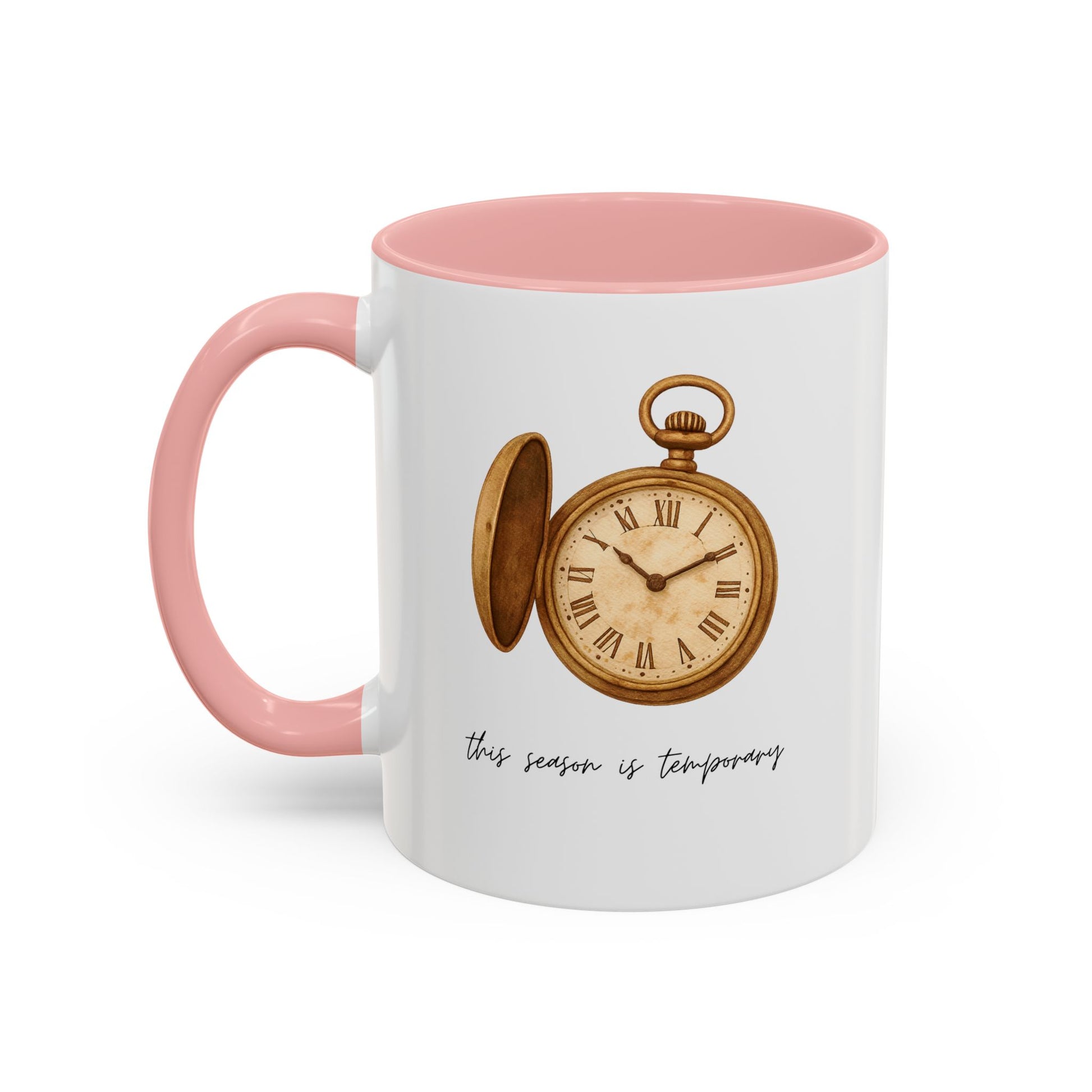 A white ceramic coffee mug with a pink interior and handle, featuring a vintage-style illustration of an open gold pocket watch and the text 'this season is temporary' in black script.